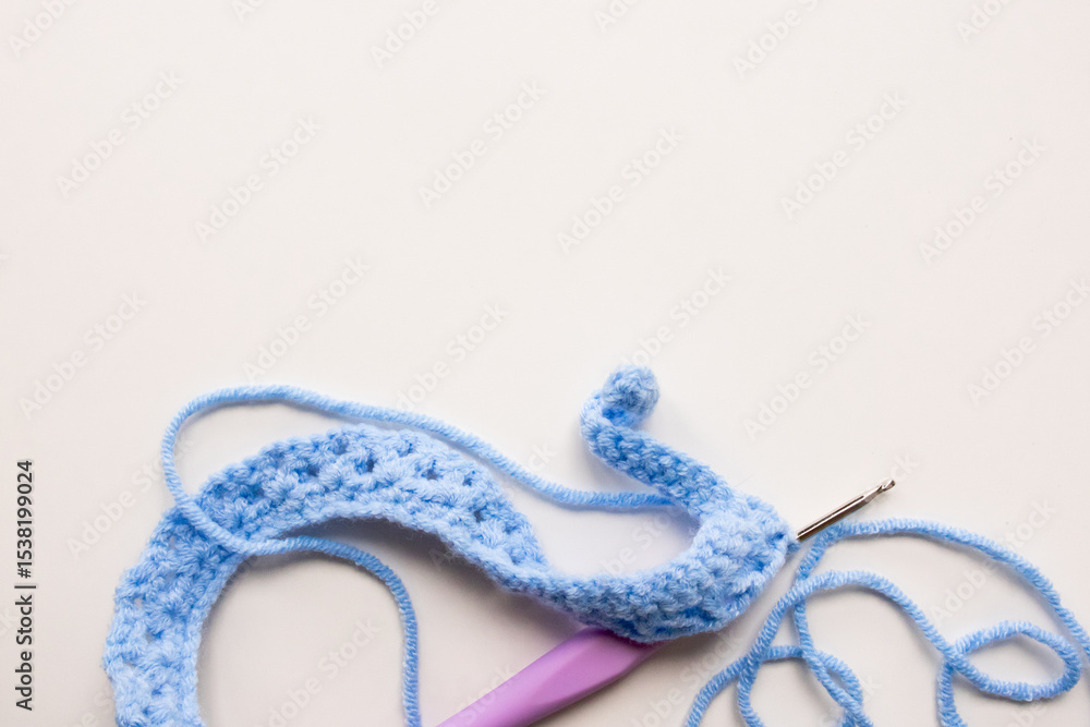 Fototapeta premium Blue crochet yarn with hook on white background