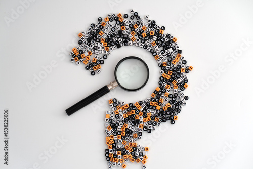 A black loupe positioned at the center of scattered letters and numbers forming a large question mark, symbolizing curiosity, analysis, and the search for answers