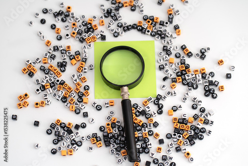 A blank of green paper magnified under a magnifying glass, surrounded by a scattered assortment of letters and numbers, symbolizing potential for discovery, interpretation, the formation of meaning