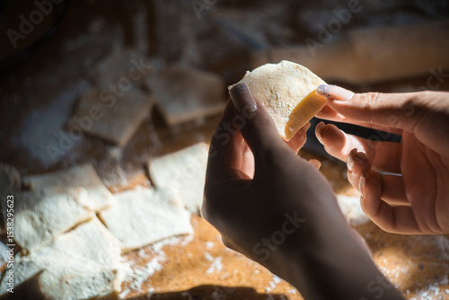 Wallpaper Mural Soft natural light highlights hands shaping homemade dough squares on a floured wooden table. Perfect for baking blogs, recipe sites, or artisan kitchen ads. Warm, authentic, and inviting. Torontodigital.ca