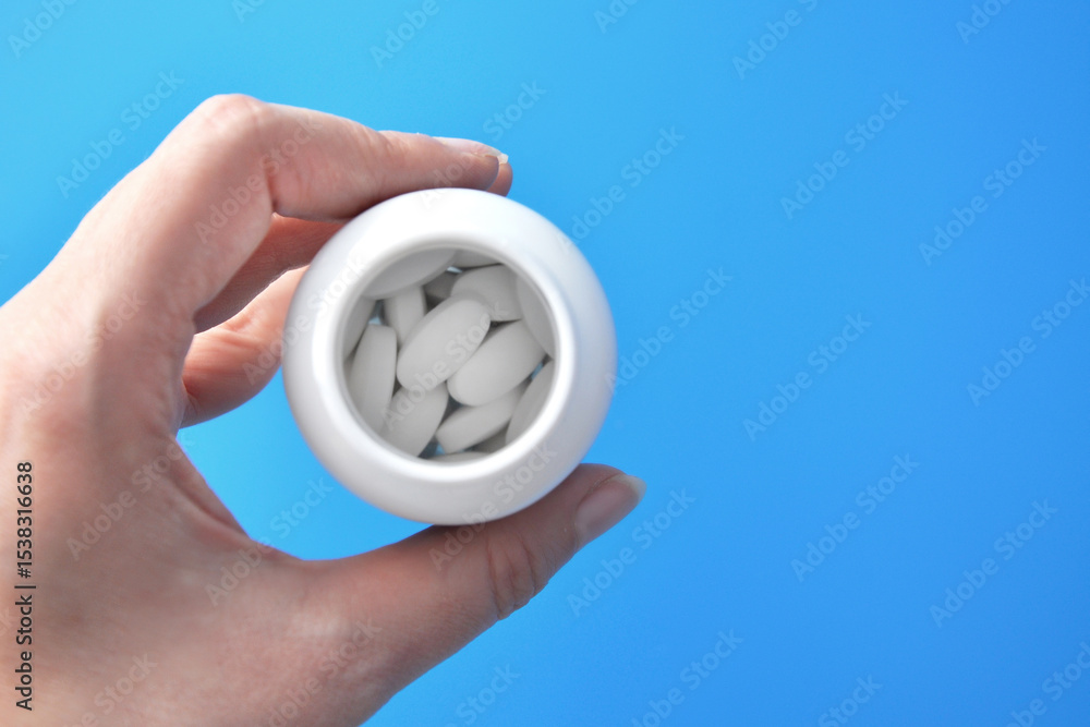 Fototapeta premium Large white pills in a medicine jar, treatment and health care