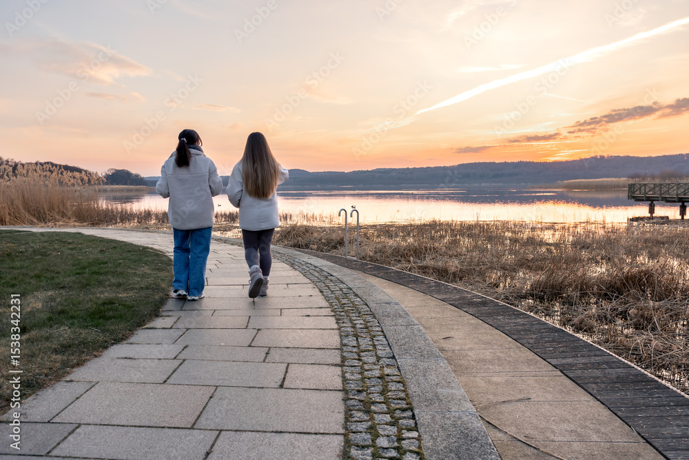 Fototapeta premium Walk along the promenade. A walk by the sea. Walking in nature. Sunset.