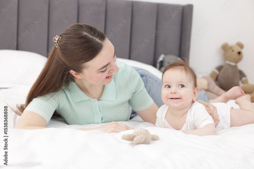 Mother with her cute little baby on bed at home Mother with her cute little baby on bed at home