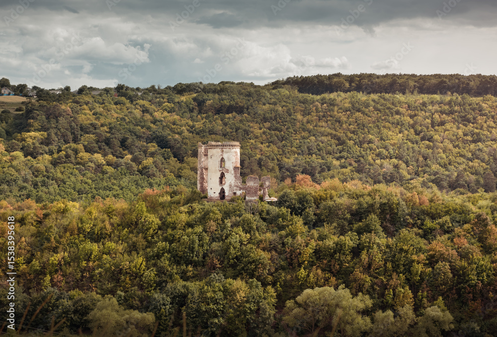 Fototapeta premium Chervonohorod Castle on a steep hill in the middle of the valley of the Dzhuryn river. Two tower ruins of abandoned castle near Nyrkiv, Ukraine.