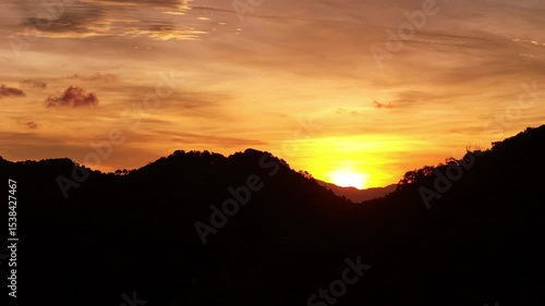 Wallpaper Mural breathtaking sunset over the ocean, painting the sky in vibrant orange, red, and purple hues above the silhouette of coastal buildings and anchored ships. Peaceful and cinematic Torontodigital.ca