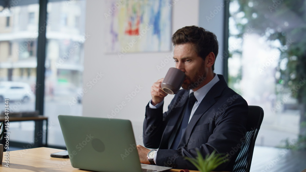 Focused manager looking computer screen workplace closeup. Man making coffee sip Focused manager looking computer screen workplace closeup. Man making coffee sip