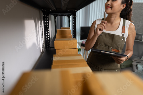 a female employee is checking parcel boxes in a warehouse, a warehouse manager is counting parcel boxes on shelves, a small online business owner is in a storage room