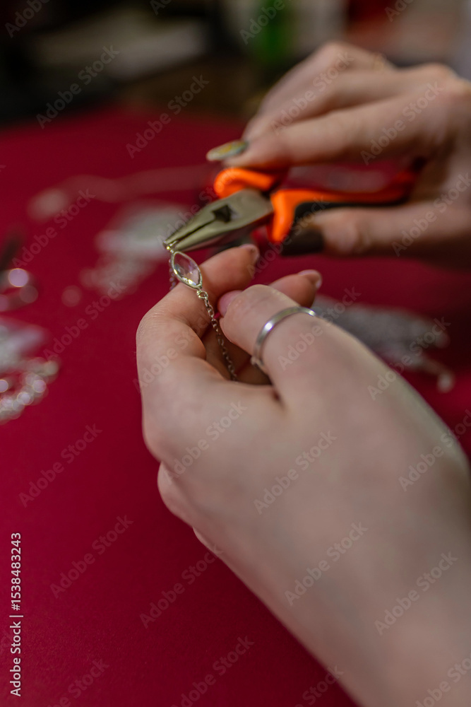 Fototapeta premium Repair of gold jewelry. Hands of the jeweler with tools and jewellery isolated on white background.