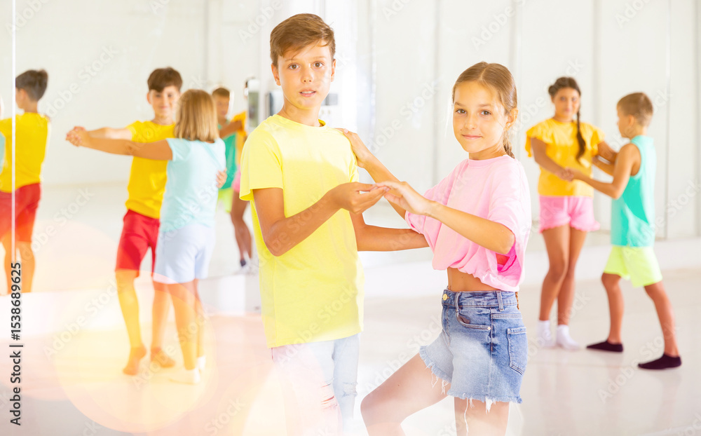 Naklejka premium Portrait of active children enjoying of partner dance in class