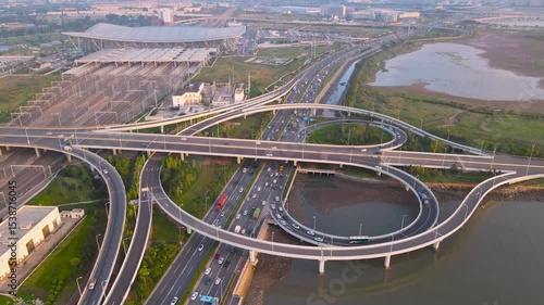 Aerial perspective of Jiaozhou Bay Viaduct showcasing morning traffic and surrounding cityscape in Qingdao, China