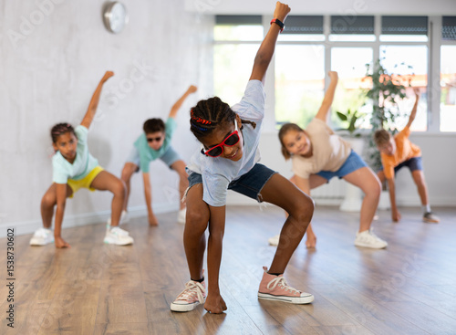 Bild auf Leinwand Smiling preteenage boy and girl in sunglasses dancer practicing active dance in