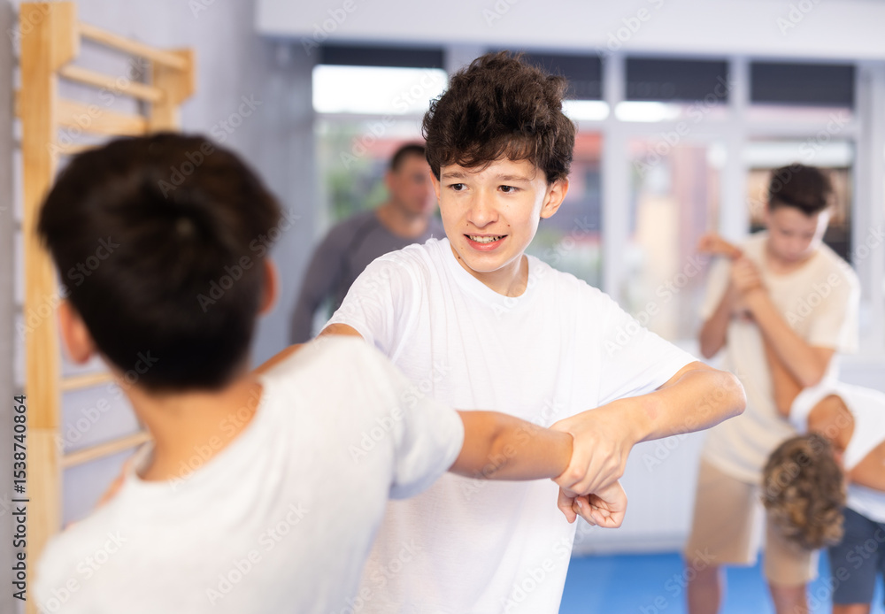 Obraz premium Sedulous underage practitioner of self-defense courses applying attack methods on his opponent