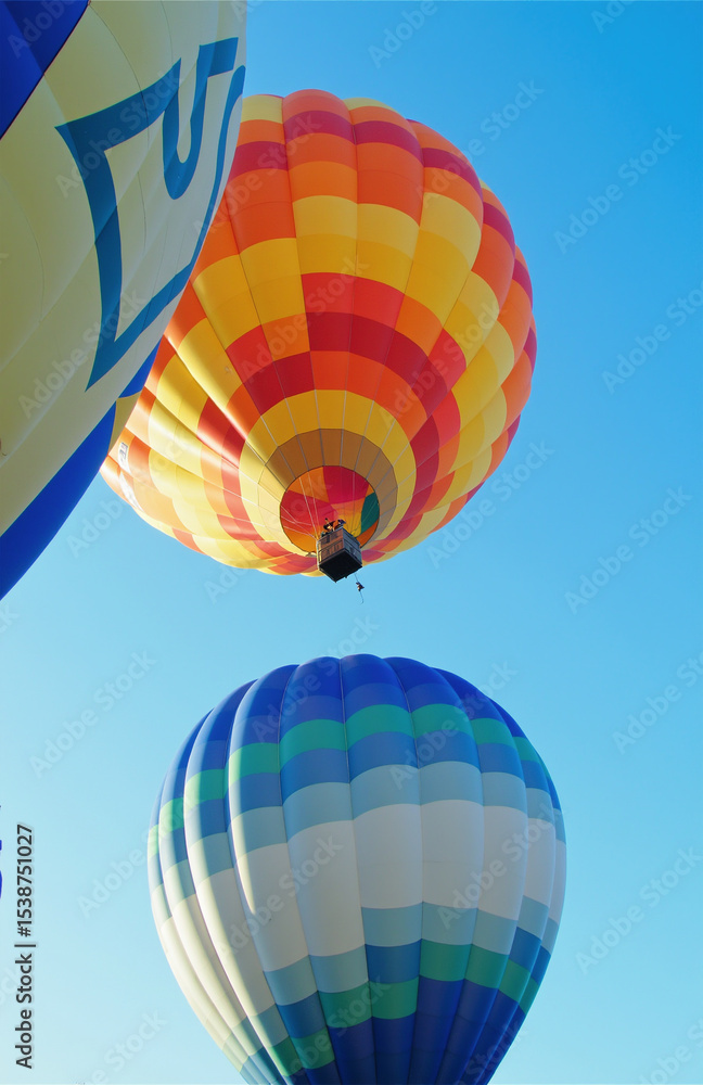 Naklejka premium Colorful hot air balloons ascending against clear blue sky.