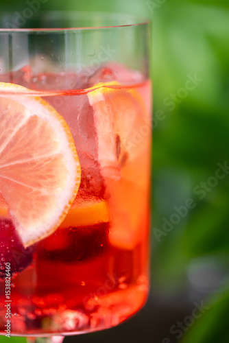 Wallpaper Mural A refreshing red drink in a glass with ice cubes and citrus slices, creating a vibrant summer aesthetic. Condensation on the glass enhances the cool, thirst-quenching appeal. Torontodigital.ca