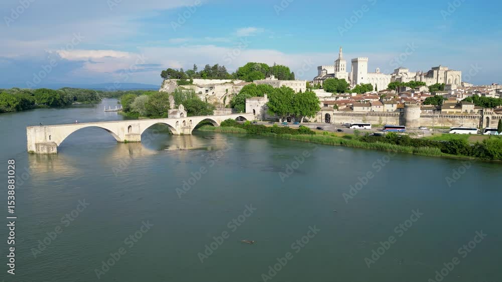 Pont d'Avignon medieval bridge with the city of Avignon, France in the background. The aerial shot shows the river and the ancient bridge in the foreground