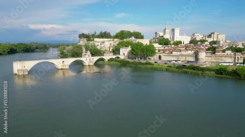 Pont d'Avignon medieval bridge with the city of Avignon, France in the background. The aerial shot shows the river and the ancient bridge in the foreground