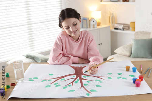 Bild auf Leinwand Girl drawing her family tree with paints at wooden table indoors