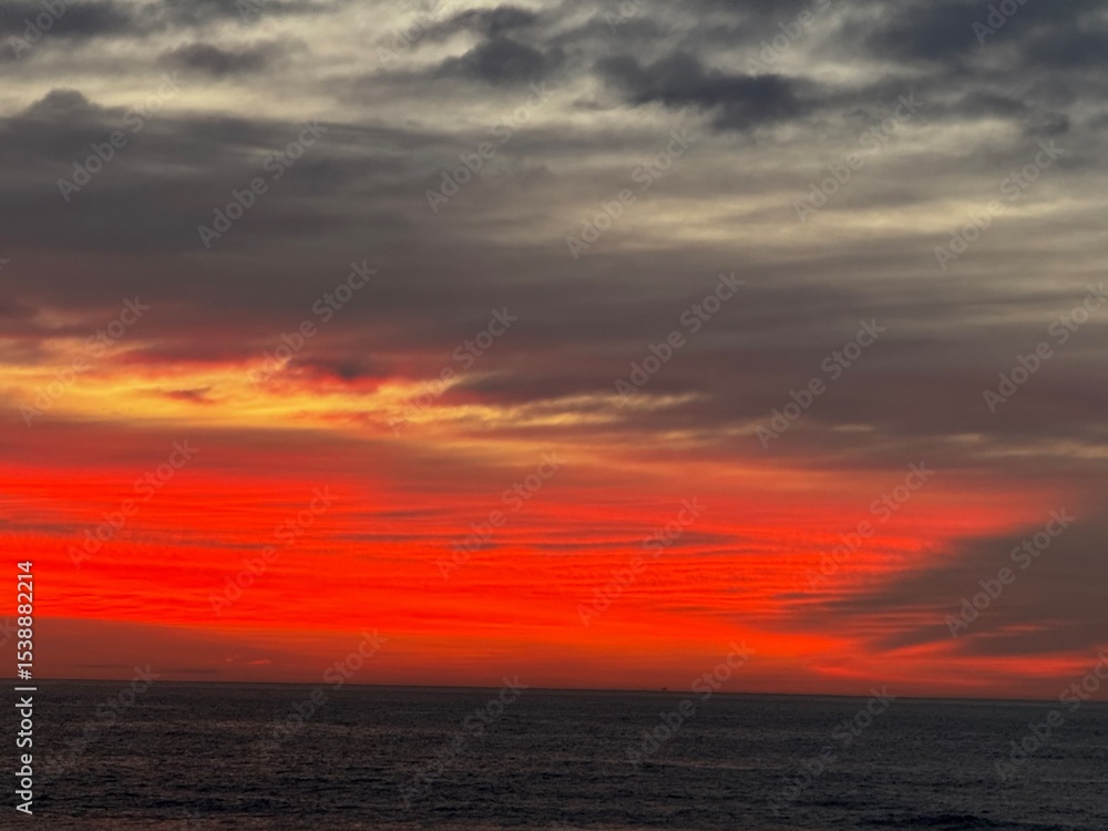 Fototapeta premium Vivid Red and Orange Sunrise Lighting Up the Morning Sky