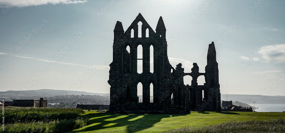 Fototapeta premium Majestic ruins of Whitby Abbey silhouetted against the sky, a captivating landmark in North York Moors National Park, UK