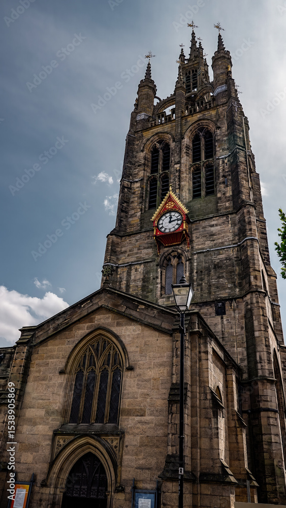 Obraz premium The imposing Newcastle Cathedral stands tall against a backdrop of clouds, its clock tower a prominent feature in the cityscape