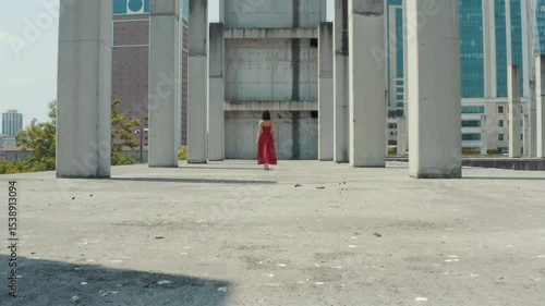 Wallpaper Mural Tracking shot follows a woman in a red dress walking through a concrete structure towards a modern city. A cinematic metaphor for a journey, ambition, and the future. Torontodigital.ca