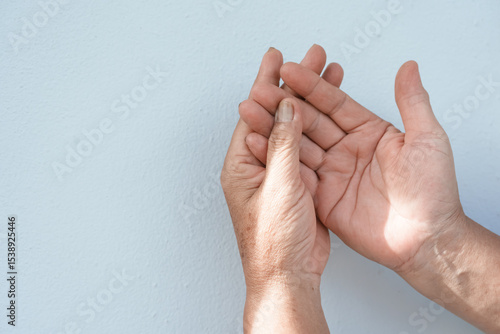 A woman uses her other hand to feel pain and tingling. along with Guillain-Barre syndrome and numbness in the hands Elderly woman tries to massage herself to relieve wrist pain