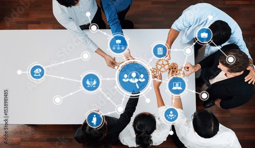 Photos A diverse team engages in collaboration while surrounded by technology icons and gears, symbolizing innovation and strategic teamwork in a modern work environment