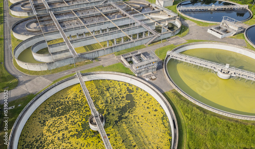 Eco-friendly aerial view of wastewater treatment plant near Lyon, France, with urban skyline – sustainable water management and environmental protection concept