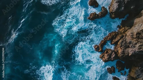 Aerial view of crashing ocean waves against rugged coastal rocks, showcasing nature's power and beauty