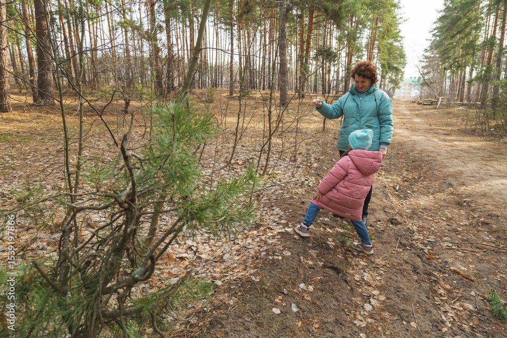 grandmother with granddaughter walking in nature in the forest grandmother with granddaughter walking in nature in the forest