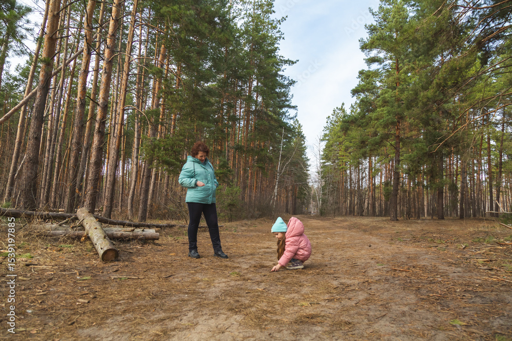 Grandmother with granddaughter walking in nature in the forest Grandmother with granddaughter walking in nature in the forest