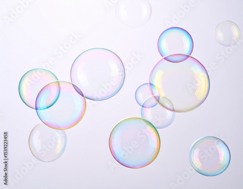 Iridescent soap bubbles floating against a soft, light background, creating a whimsical and ethereal atmosphere