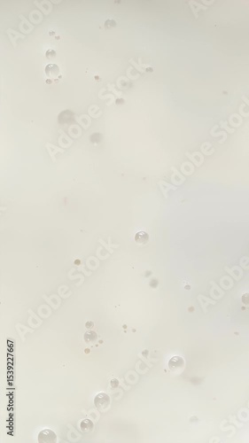 Close-up of milk surface gently rippling in soft motion, minimal and abstract footage for food and beverage backgrounds, plant-based drinks, or creamy recipes, and soft abstract background for skincar