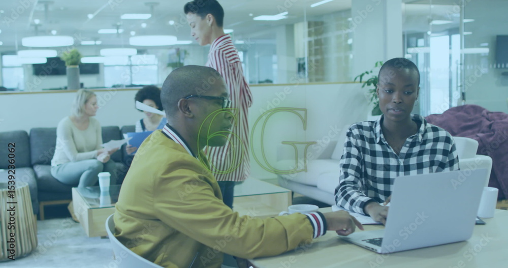 Obraz premium Collaborating man in mustard bomber jacket and woman typing at table in open office, with laptop