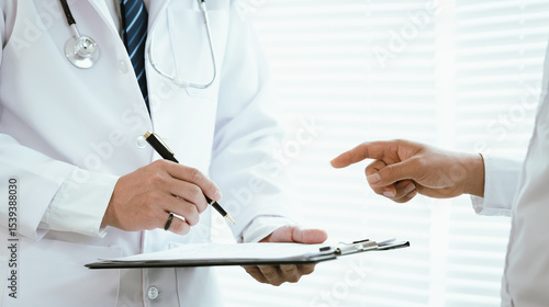 Foto A doctor, wearing a white lab coat, holds a clipboard and pen, pointing towards it while interacting with a patient, indicating explanation or signature