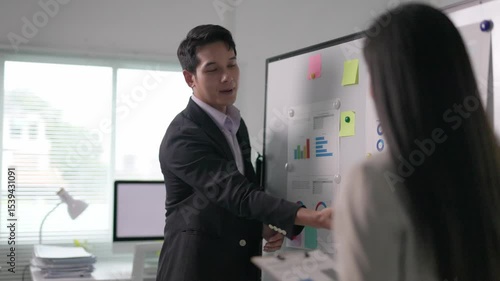 Wallpaper Mural Asian businessman presenting marketing data analysis graphs and charts on whiteboard to colleague in modern office Torontodigital.ca