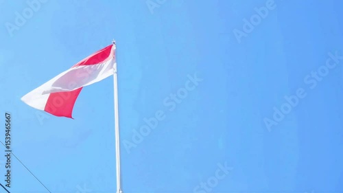 4K low angle shot of the Indonesian flag waving against the sky – symbol of national pride and independence