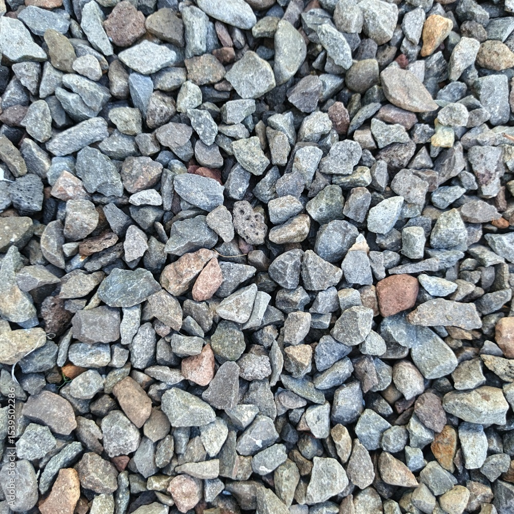 The ground surface is filled with small pebbles in gray, brown, and bluish colors. The stones have irregular shapes and natural rough textures, with even natural lighting. The ground surface is filled with small pebbles in gray, brown, and bluish colors. The stones have irregular shapes and natural rough textures, with even natural lighting.