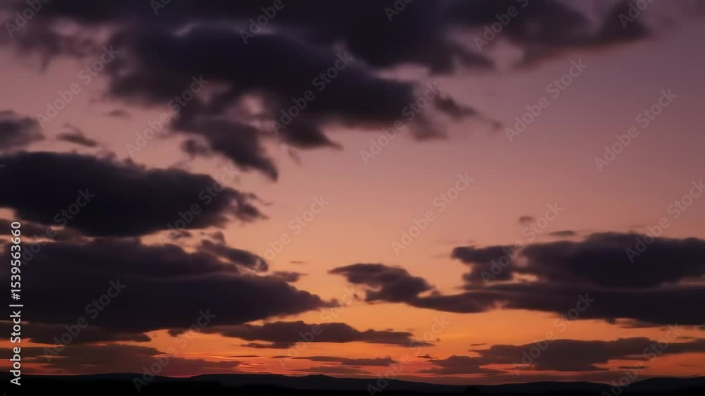 Dramatic sunset with dark clouds and orange hues Dramatic sunset with dark clouds and orange hues