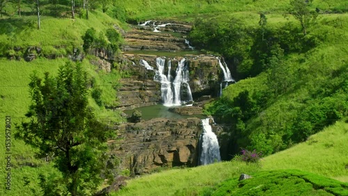Multiple tiers of St. Clair's Falls cascading through a lush green valley in Sri Lanka, creating a stunning and serene landscape filled with vibrant tropical beauty