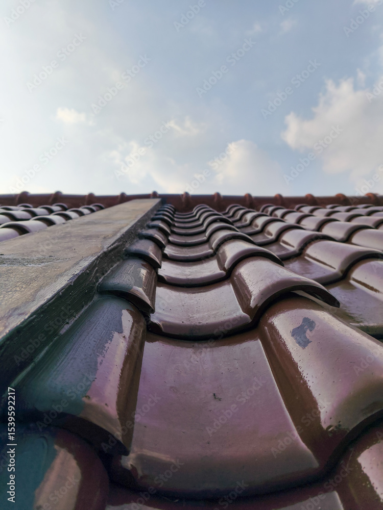Fototapeta premium Close-up view of ceramic roof tiles under a bright blue sky