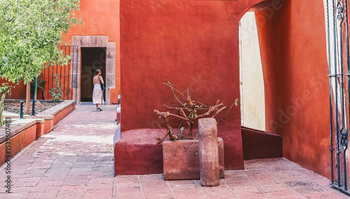 Vászonkép Tourist walking in a traditional mexican courtyard
