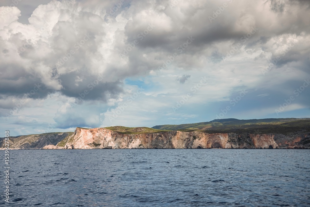 Fototapeta premium Waves gently lap against the rugged cliffs, framed by a darkening sky as adventurers set sail on a boat to discover hidden coastal treasures and vibrant marine life
