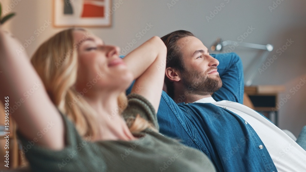 Cute man and pretty woman sitting and relaxing on sofa at home. Beautiful couple husband and wife lying on couch in living room having good time. Carefree relaxed lovely couple. Couple concept. Cute man and pretty woman sitting and relaxing on sofa at home. Beautiful couple husband and wife lying on couch in living room having good time. Carefree relaxed lovely couple. Couple concept.