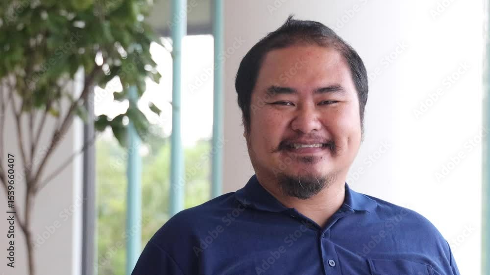 Happy smiling friendly middle aged Asian man, aged man with overweight and hair loss as signs of aging Happy smiling friendly middle aged Asian man, aged man with overweight and hair loss as signs of aging