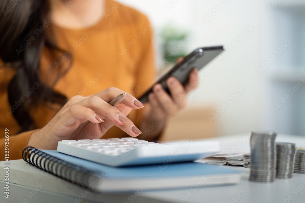 Fototapeta premium Financial Planning and Budgeting. Woman calculating expenses using smartphone and calculator.