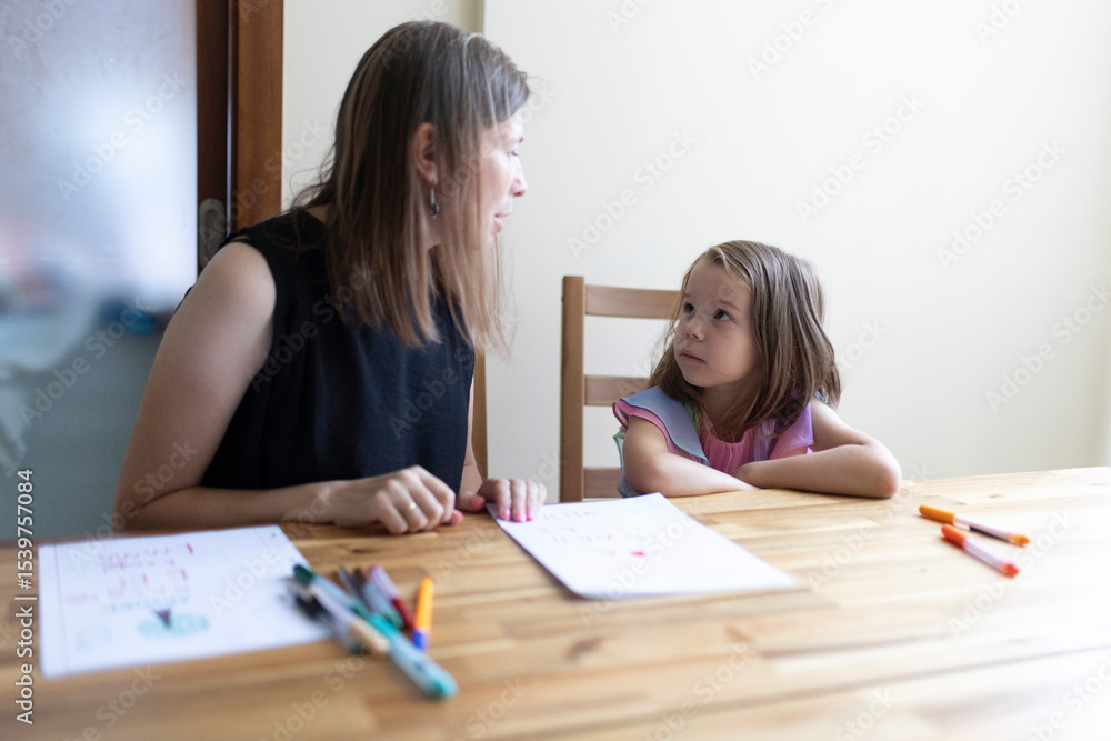 Teacher helping young girl student with homework at home Teacher helping young girl student with homework at home