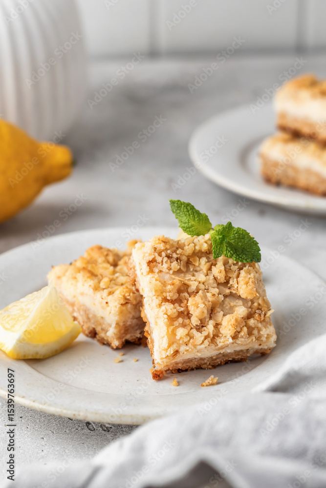 Lemon crumble bars served on a plate decorated with mint leaves on light gray background. Oatmeal lemon bars Lemon crumble bars served on a plate decorated with mint leaves on light gray background. Oatmeal lemon bars