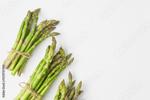 Photos Fresh green asparagus bunches on white textured background