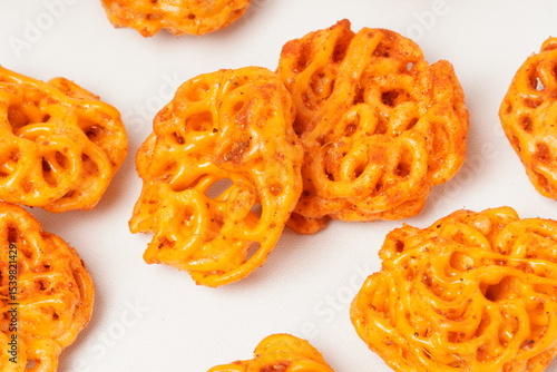 A pile of spicy Indonesian crackers or Kerupuk with spiral twists, coated in red-orange chili powder and rich spices. Bold, flavorful, and appetite-boosting. Photographed against a white background.